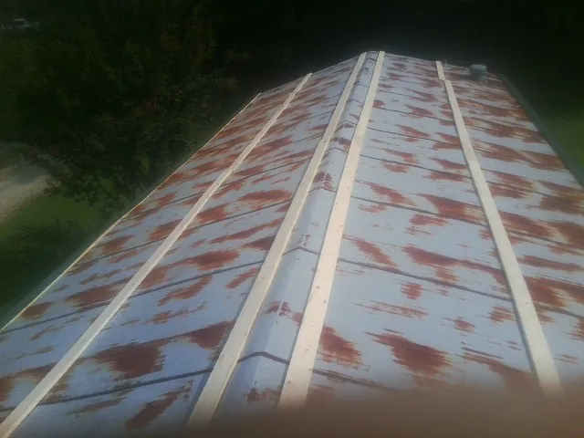 Rusted metal roof panels with new wood purlins before replacement — Storm Damage Roof Repair in Axtell by Roofing Brothers