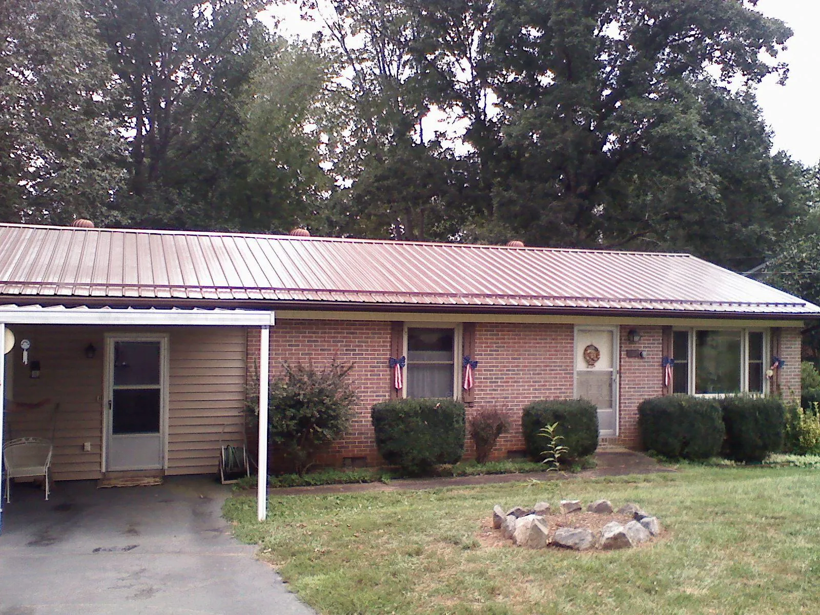 Bronze metal roof and carport on a brick ranch home — Roof Repair work by our crew in Axtell